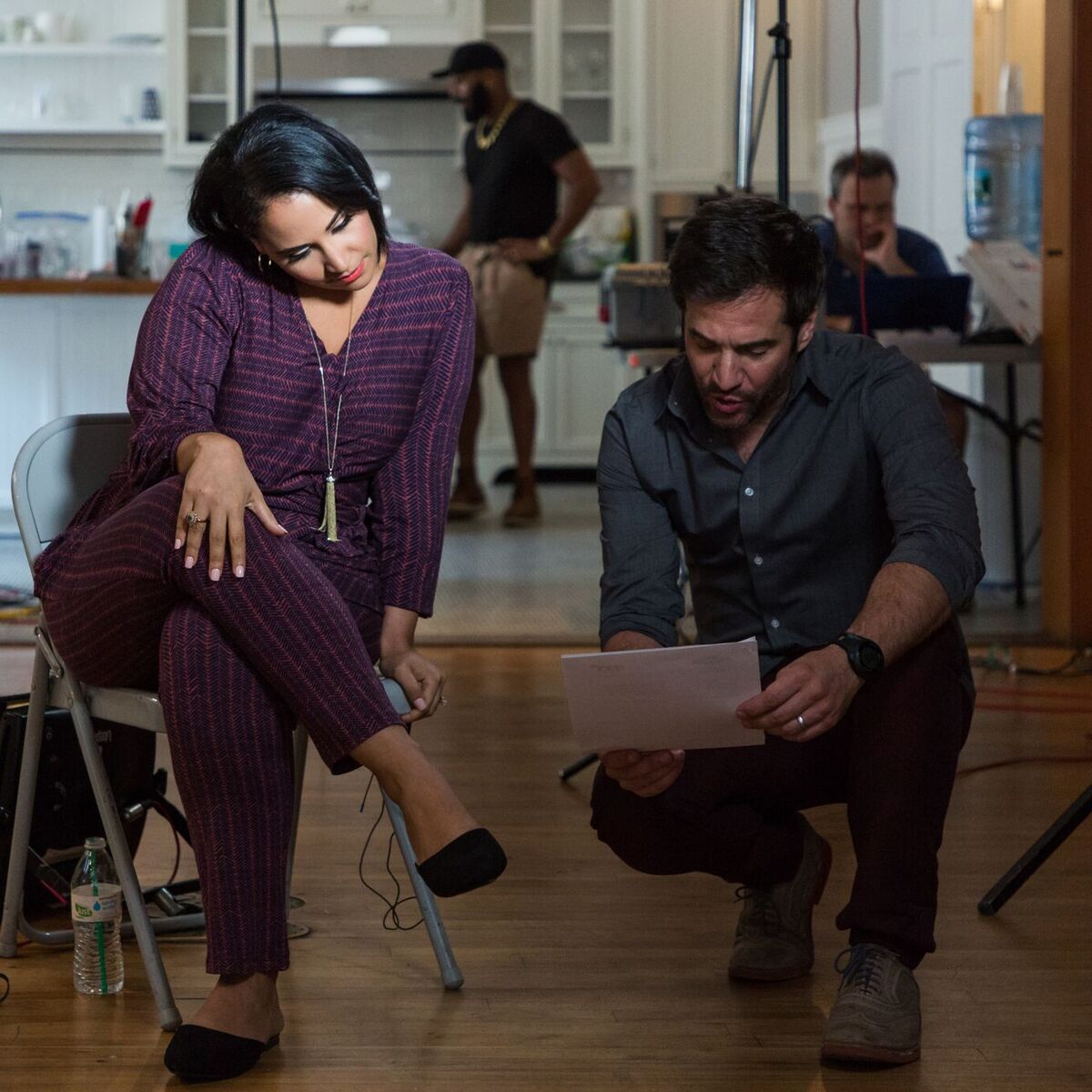 JD Roberto reviewing script with talent on set